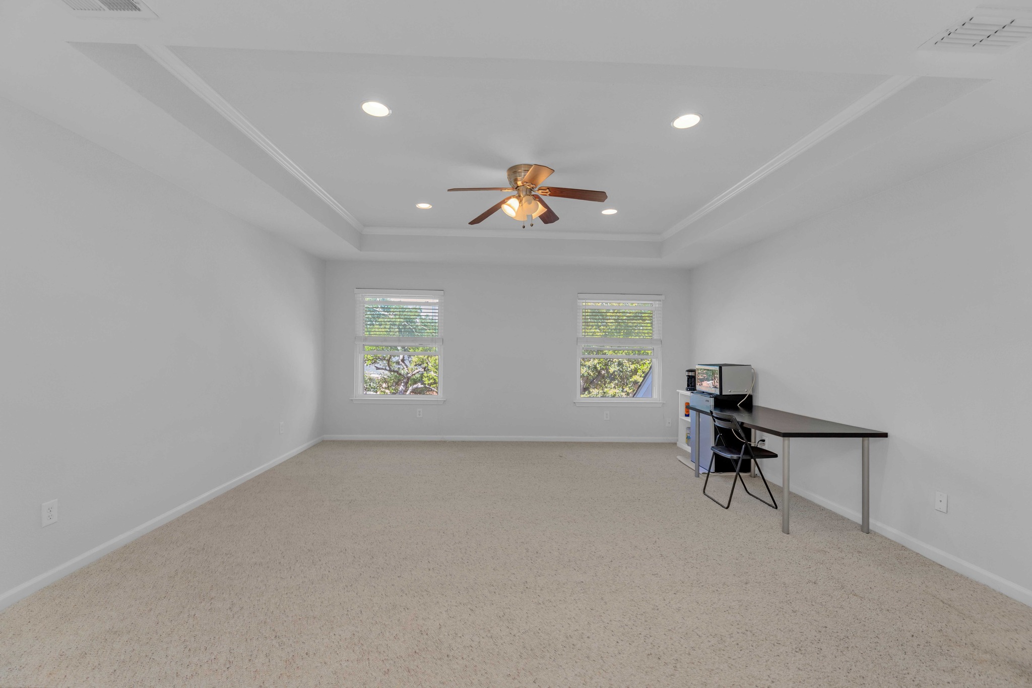 12528 Labrador Cove Austin, TX 78729 - Photo 32 of 40 Upstairs Loft / Game Room: Oversized open-concept loft with tray ceiling detail and recessed lighting, offering exceptional flexibility for a media room, game room, home office, or secondary living space. Overlooks the main level with iron railing detail and is filled with natural light from multiple windows, creating an inviting and functional extension of the home.