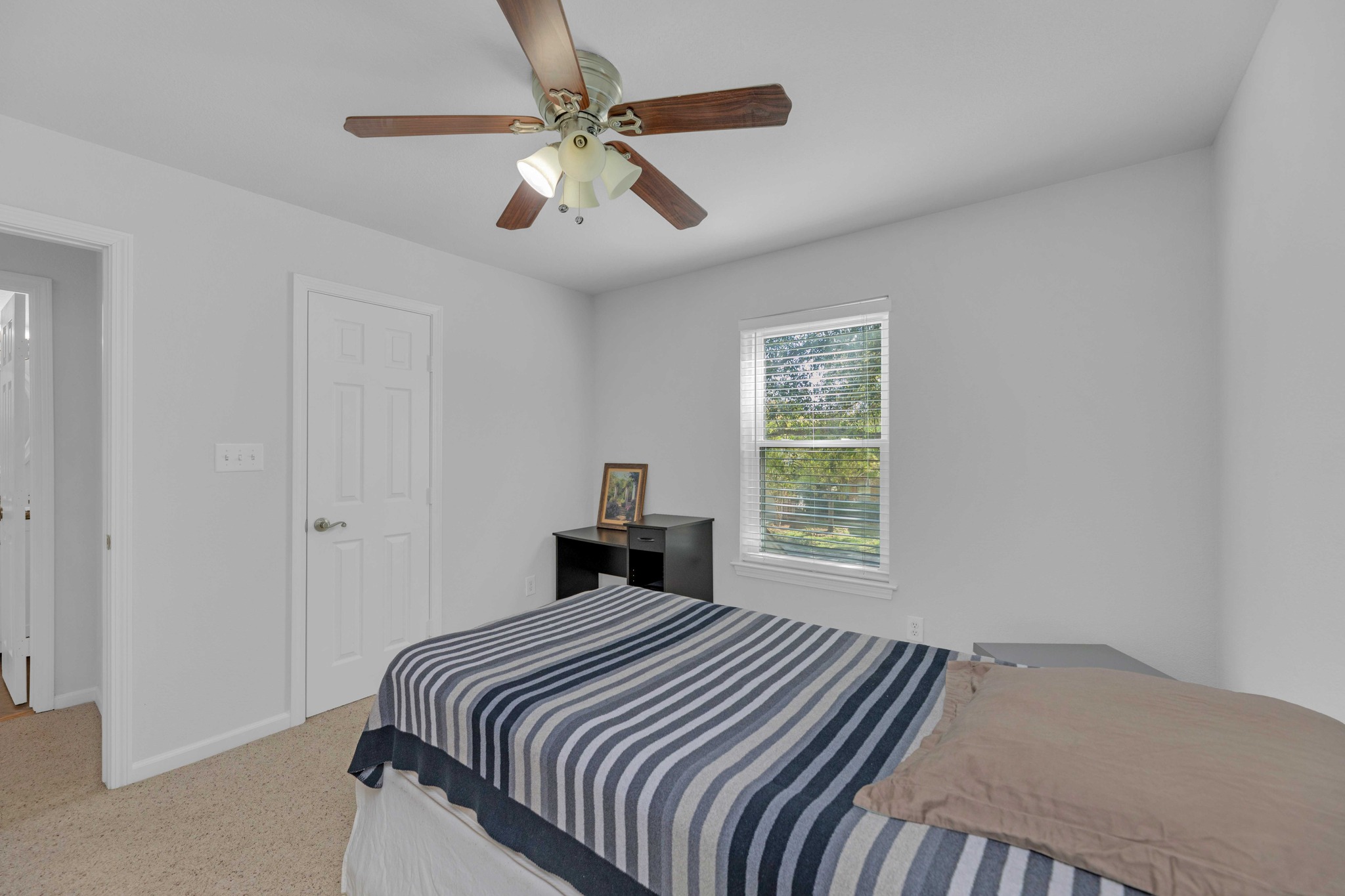 12528 Labrador Cove Austin, TX 78729 - Photo 33 of 40 Well-sized secondary bedroom with large window, neutral finishes, and a functional layout that allows for flexible use. Positioned just across the hallway from a full bathroom, this space creates an ideal private guest suite setup, offering both comfort and convenience for visitors or extended stays.