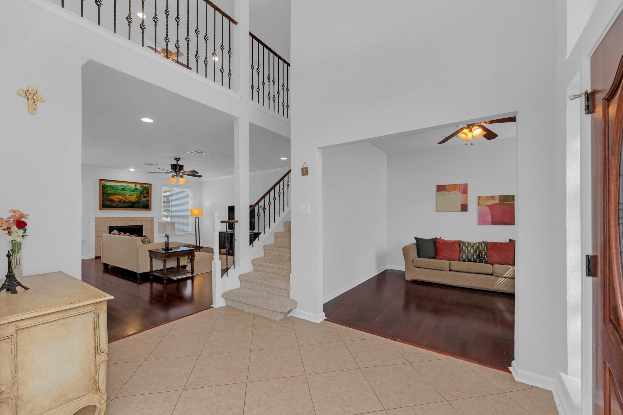 12528 Labrador Cove Austin, TX 78729 - Photo 4 of 40 Living Areas: Open concept layout with soaring ceilings, rich wood flooring, and abundant natural light. The family room features a fireplace and flows seamlessly from the entry, while the open staircase with wrought iron railings adds architectural interest and connects both levels.