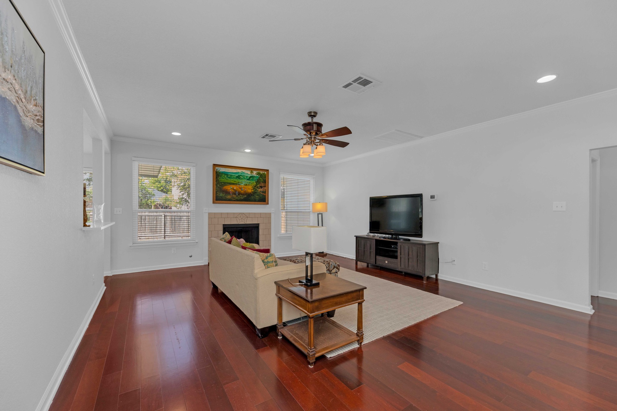 12528 Labrador Cove Austin, TX 78729 - Photo 8 of 40 Family Room: Generous open living space with rich wood flooring, fireplace focal point, and abundant natural light. Designed for comfort and functionality, with seamless flow and ample room for everyday living and entertaining.