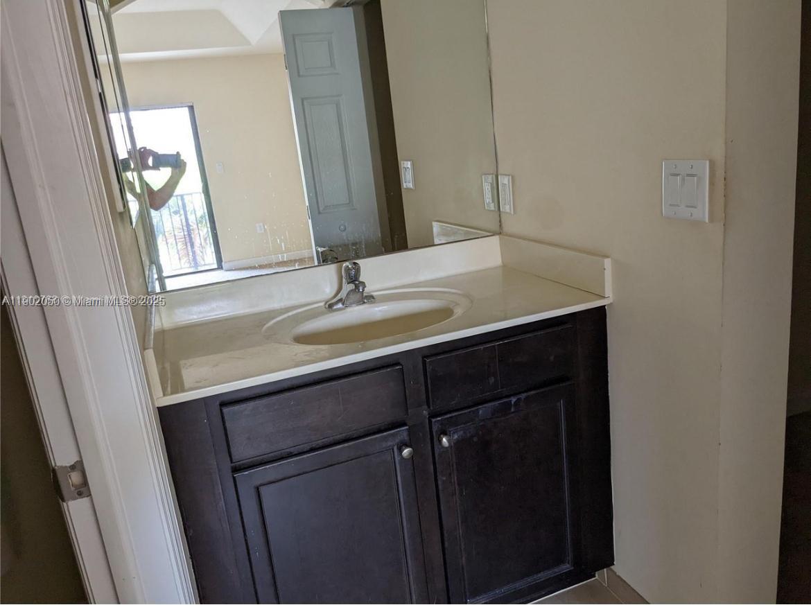 22411 Southwest 88th Place, Unit 926 Cutler Bay, FL 33190 - Photo 12 of 16 a bathroom with a sink and a mirror