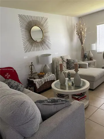 a living room with furniture and a large mirror