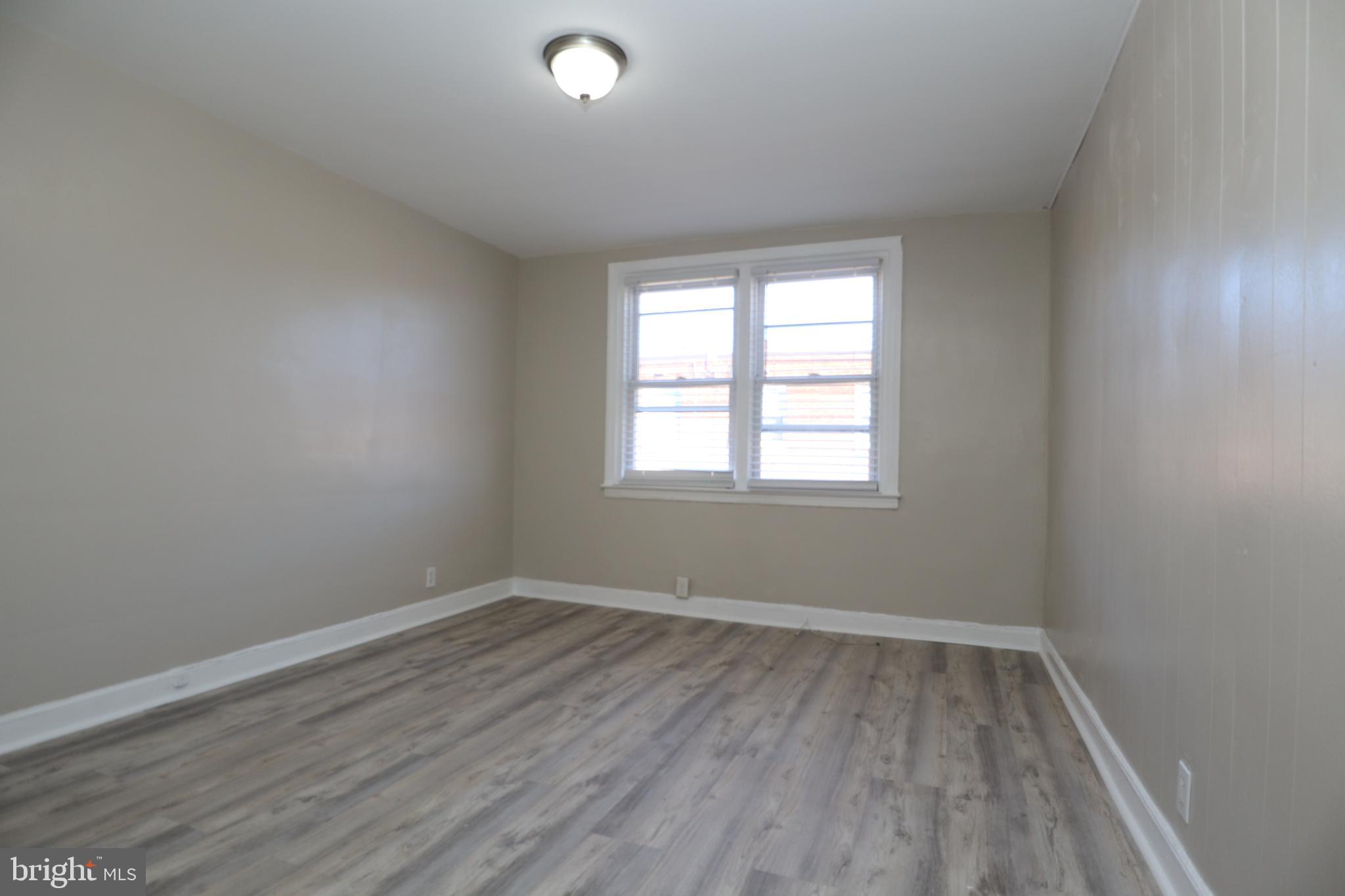 6335 Carnation Street, Unit 2 Philadelphia, PA 19144 - Photo 12 of 35 an empty room with wooden floor and windows