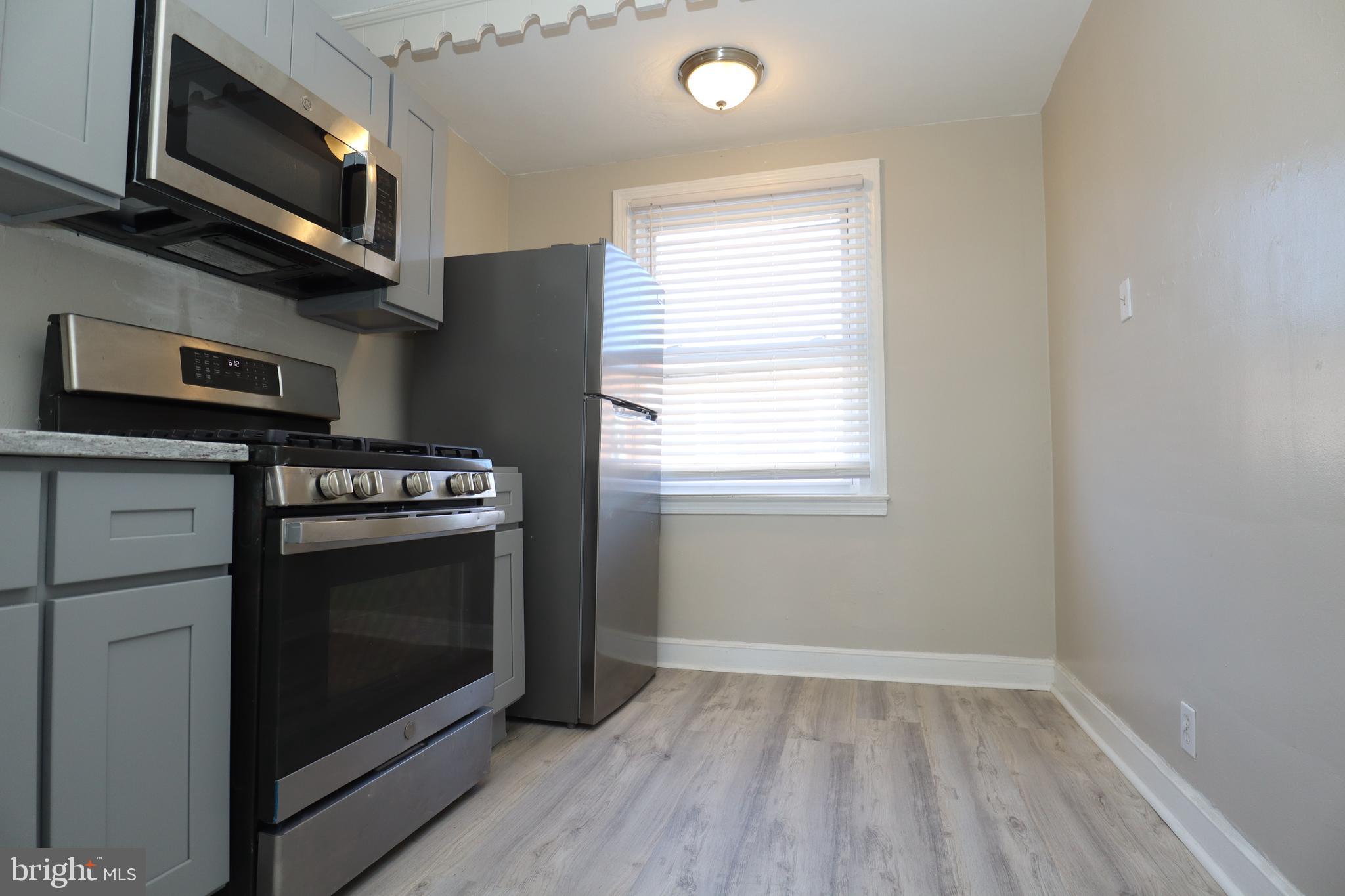 6335 Carnation Street, Unit 2 Philadelphia, PA 19144 - Photo 14 of 35 a kitchen with stainless steel appliances a stove microwave and sink