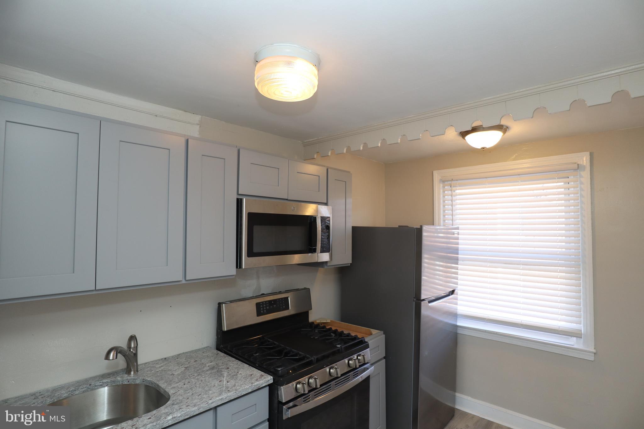 6335 Carnation Street, Unit 2 Philadelphia, PA 19144 - Photo 16 of 35 a kitchen with a sink a window stainless steel appliances and cabinets