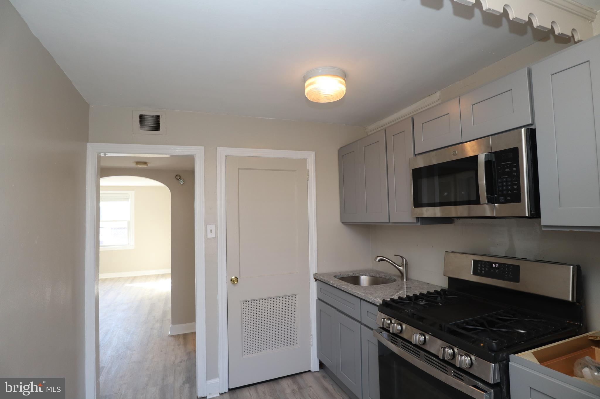 6335 Carnation Street, Unit 2 Philadelphia, PA 19144 - Photo 17 of 35 a kitchen with stainless steel appliances granite countertop a stove and a microwave