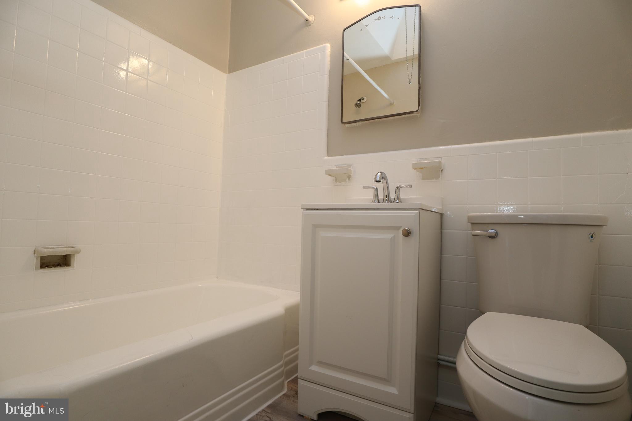 6335 Carnation Street, Unit 2 Philadelphia, PA 19144 - Photo 18 of 35 a bathroom with a granite countertop toilet a sink and bathtub