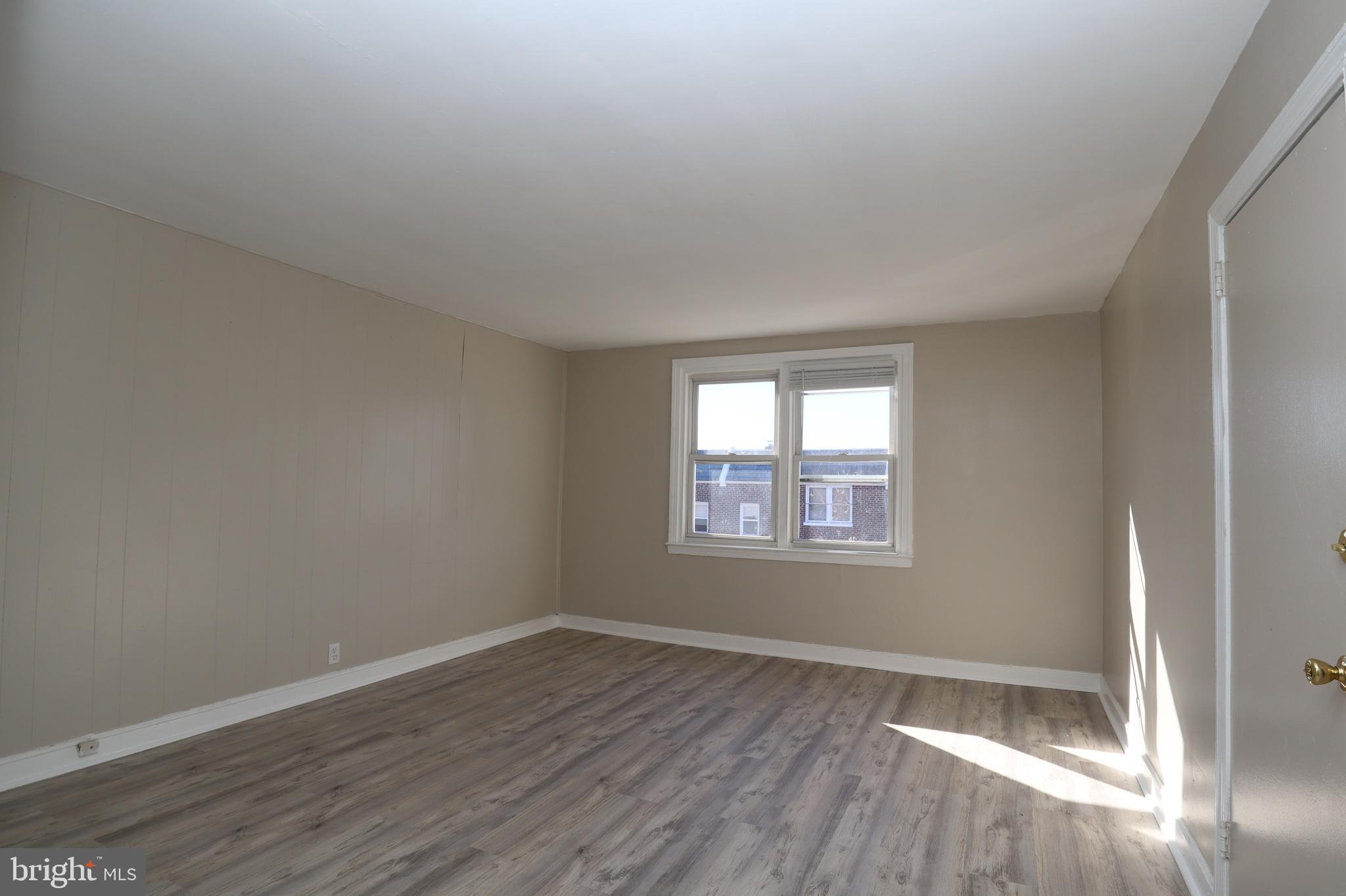 6335 Carnation Street, Unit 2 Philadelphia, PA 19144 - Photo 2 of 35 a view of an empty room with wooden floor and a window