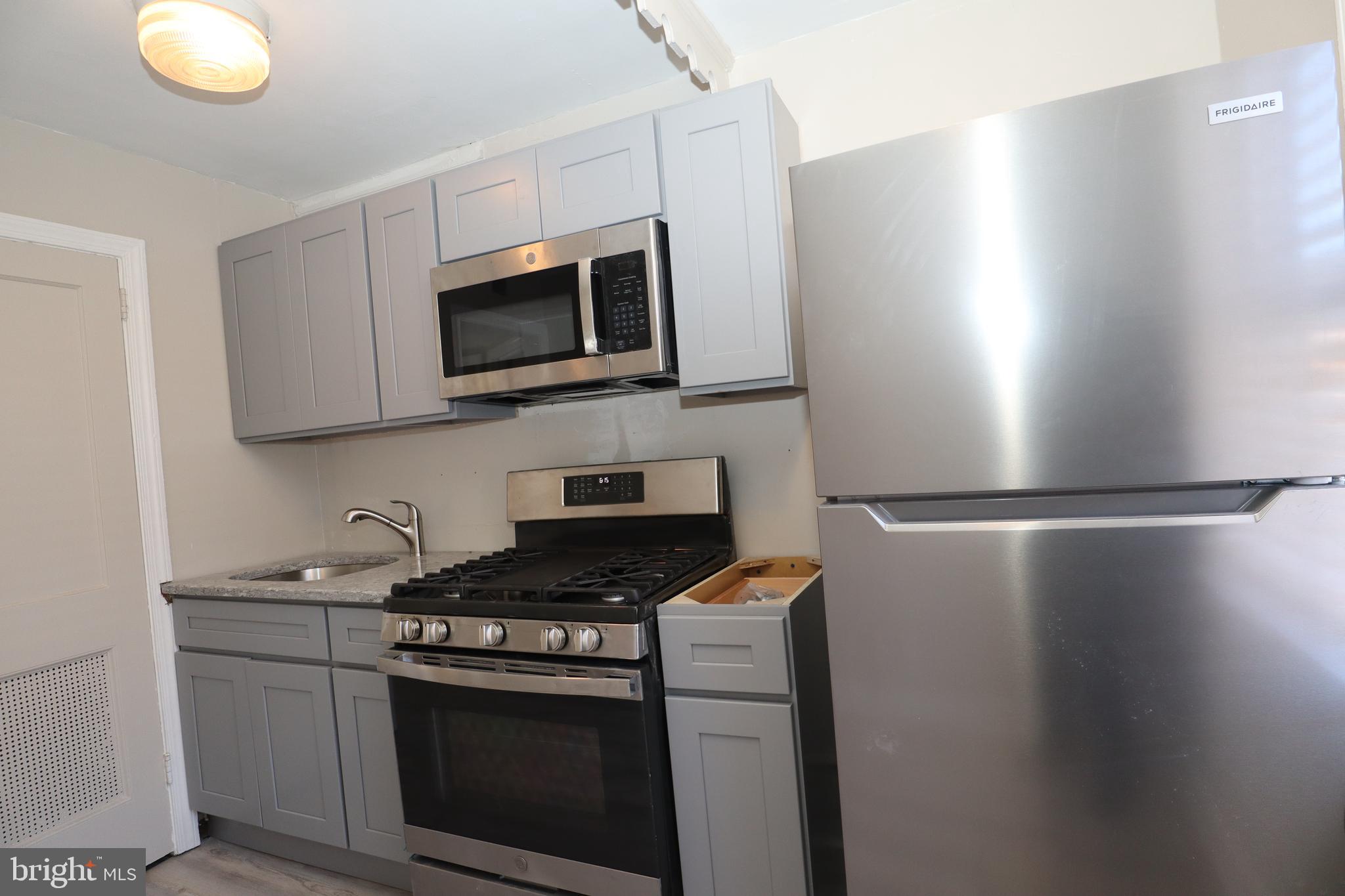 6335 Carnation Street, Unit 2 Philadelphia, PA 19144 - Photo 27 of 35 a kitchen with stainless steel appliances white cabinets and a stove
