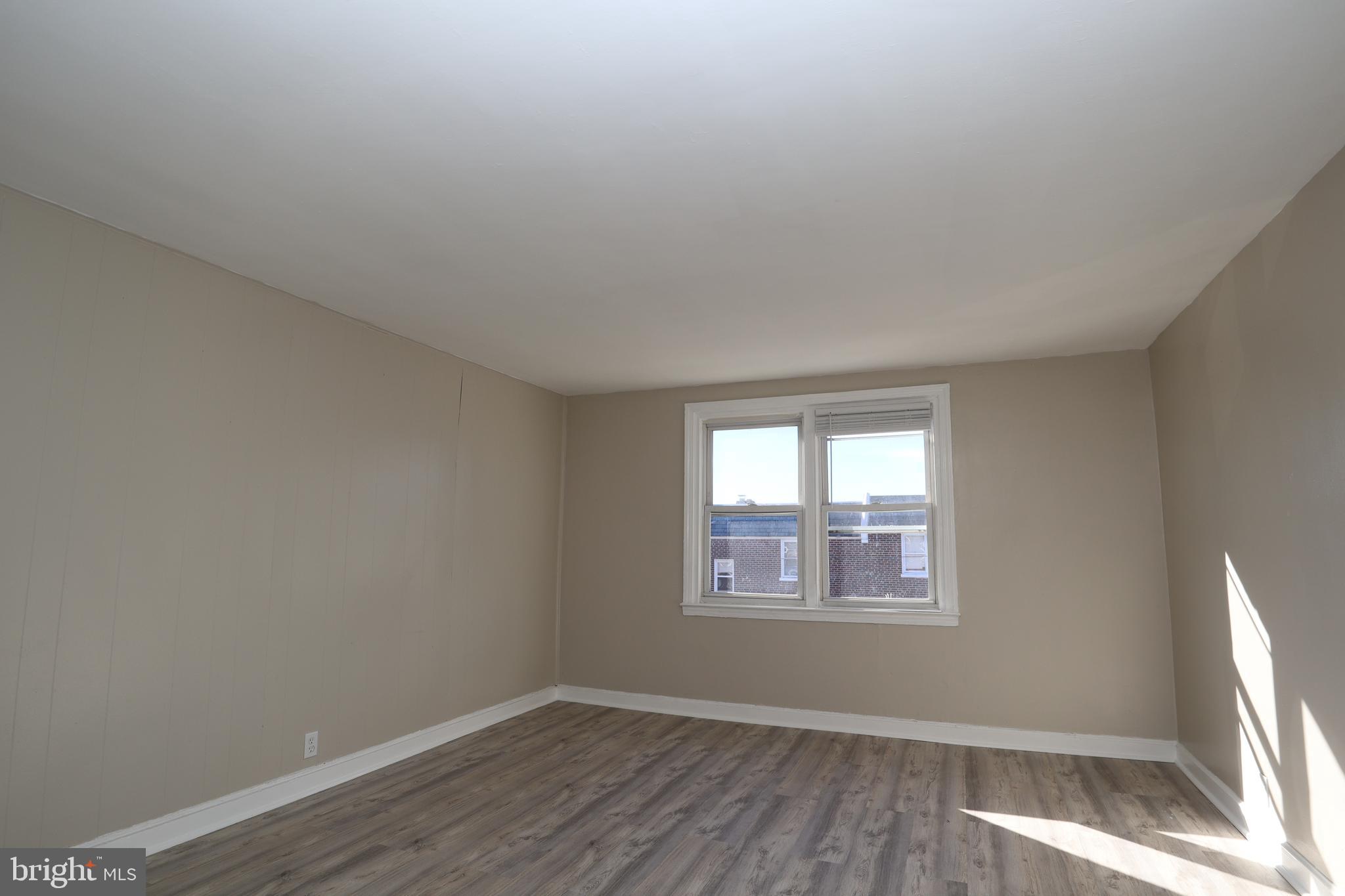 6335 Carnation Street, Unit 2 Philadelphia, PA 19144 - Photo 3 of 35 an empty room with wooden floor and windows