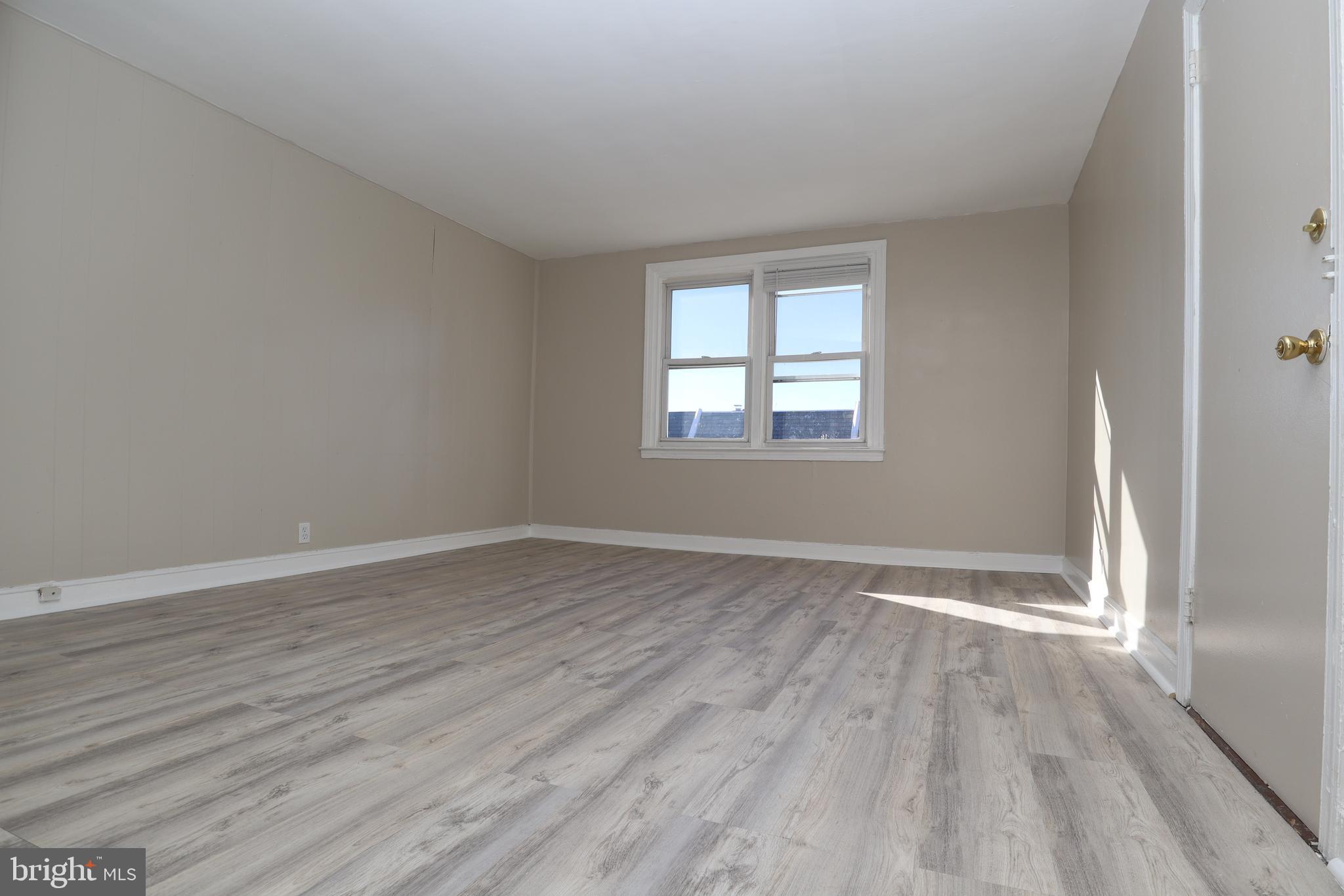 6335 Carnation Street, Unit 2 Philadelphia, PA 19144 - Photo 4 of 35 a view of an empty room with wooden floor and a window
