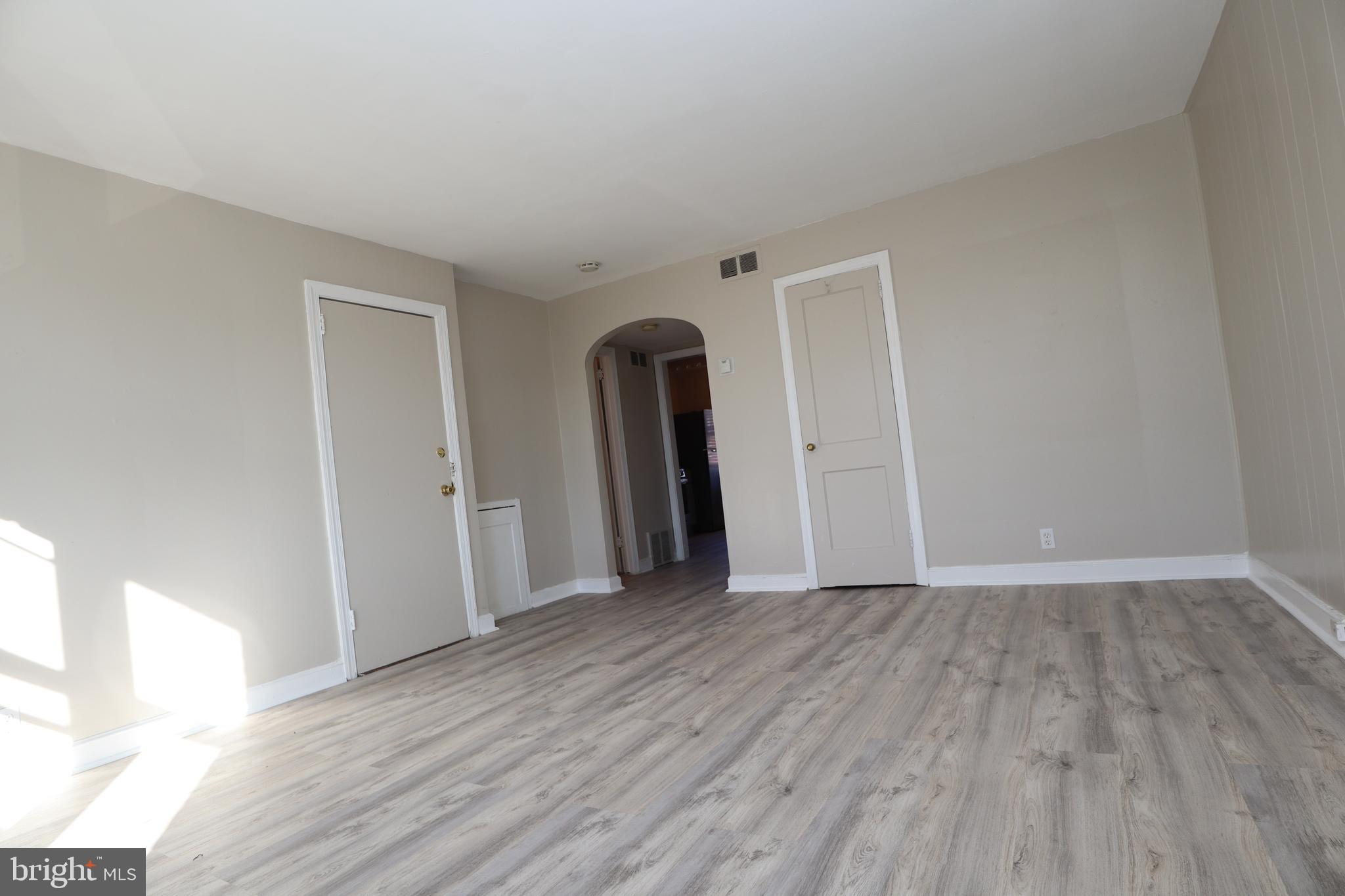 6335 Carnation Street, Unit 2 Philadelphia, PA 19144 - Photo 5 of 35 a view of an empty room with wooden floor and a window