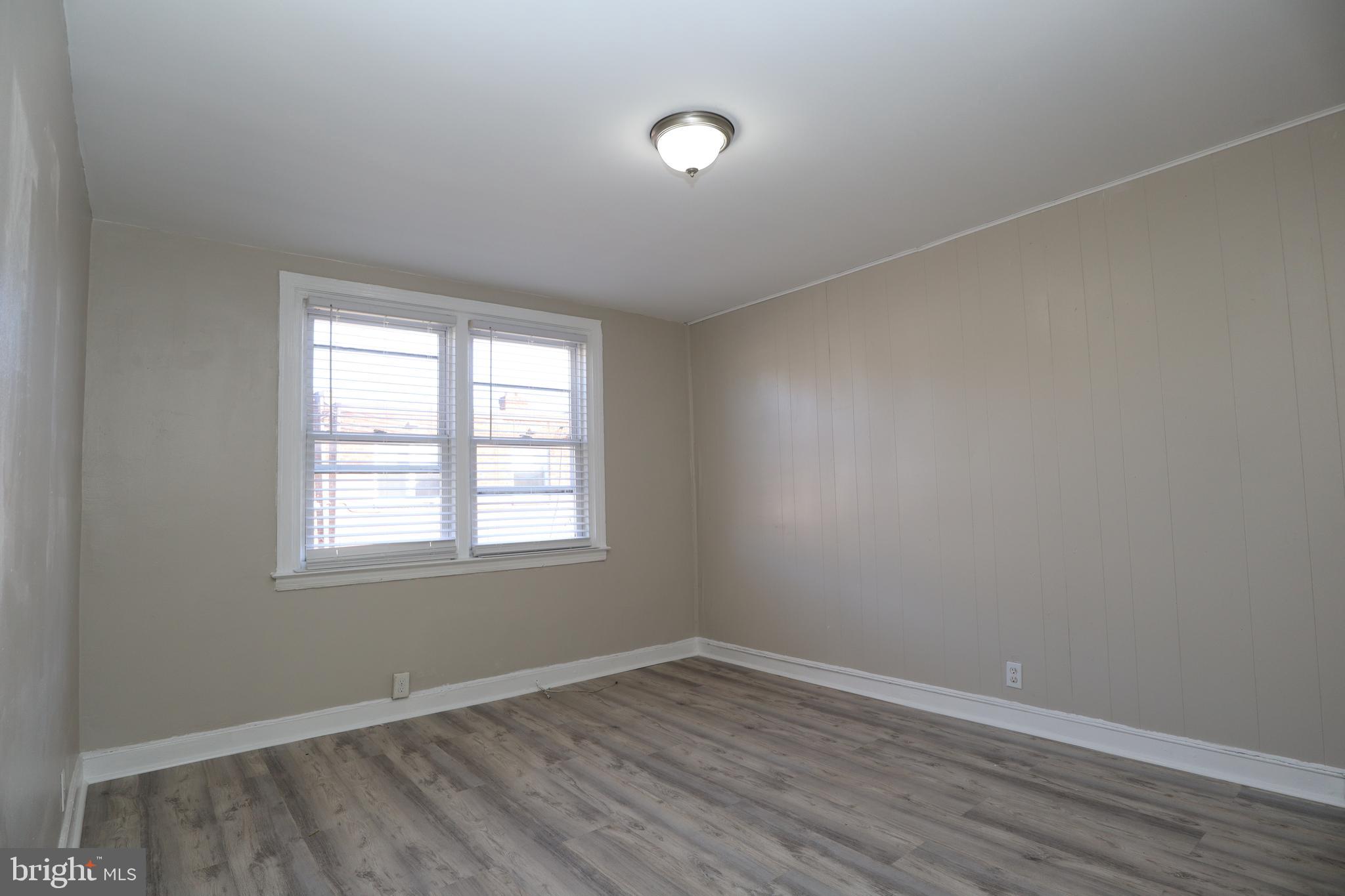 6335 Carnation Street, Unit 2 Philadelphia, PA 19144 - Photo 7 of 35 an empty room with wooden floor and windows