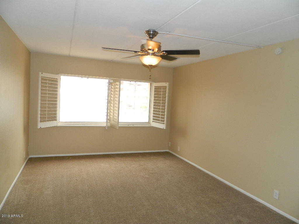 7830 East Camelback Road, Unit 212 Scottsdale, AZ 85251 - Photo 21 of 45 an empty room with a window and a ceiling fan