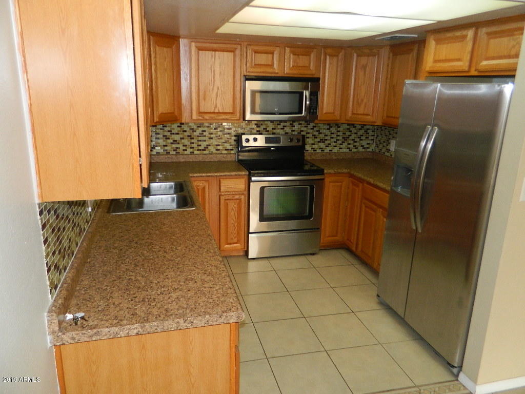 7830 East Camelback Road, Unit 212 Scottsdale, AZ 85251 - Photo 3 of 45 a kitchen with stainless steel appliances granite countertop a refrigerator a stove and a sink