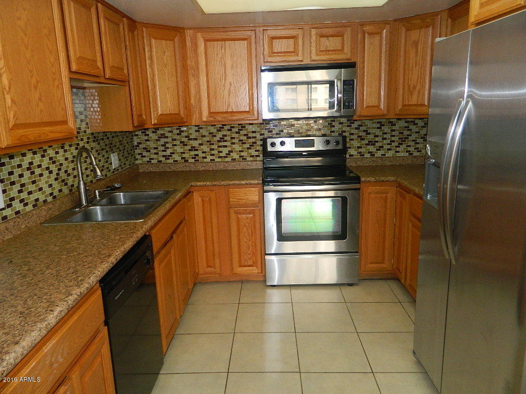 7830 East Camelback Road, Unit 212 Scottsdale, AZ 85251 - Photo 4 of 45 a kitchen with granite countertop a stove sink and cabinets