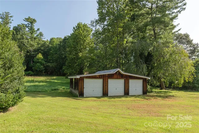 a front view of house with yard and trees in the background