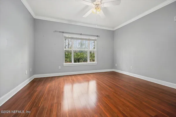 an empty room with a window and a fan