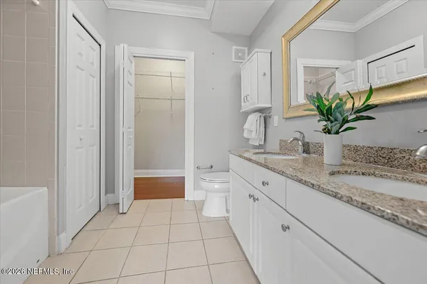 a bathroom with a granite countertop sink a toilet and a shower