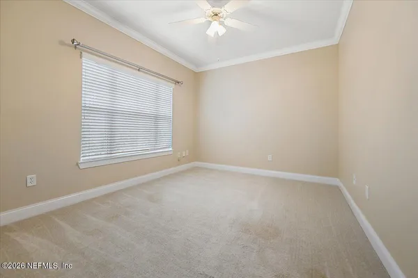 an empty room with windows and fan