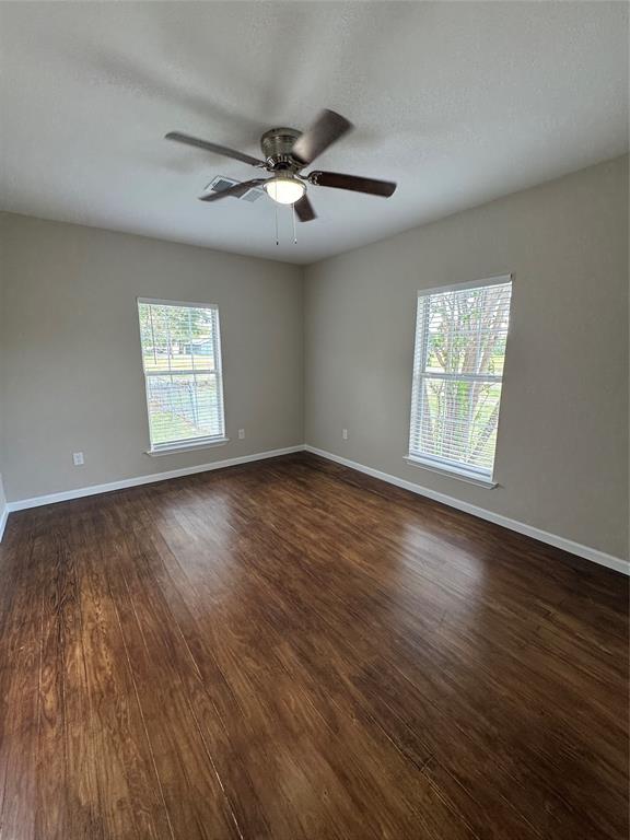306 North College Street Howe, TX 75459 - Photo 10 of 15 a view of an empty room with wooden floor and a window