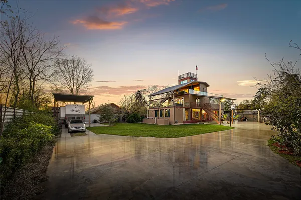 a view of a big house with a big yard and large trees
