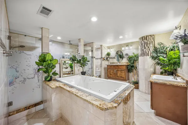 a bathroom with a granite countertop sink a mirror and shower