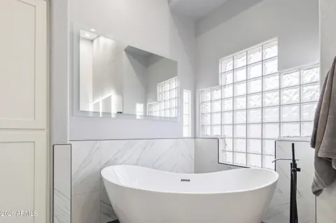 a bathroom with a white tub and shower