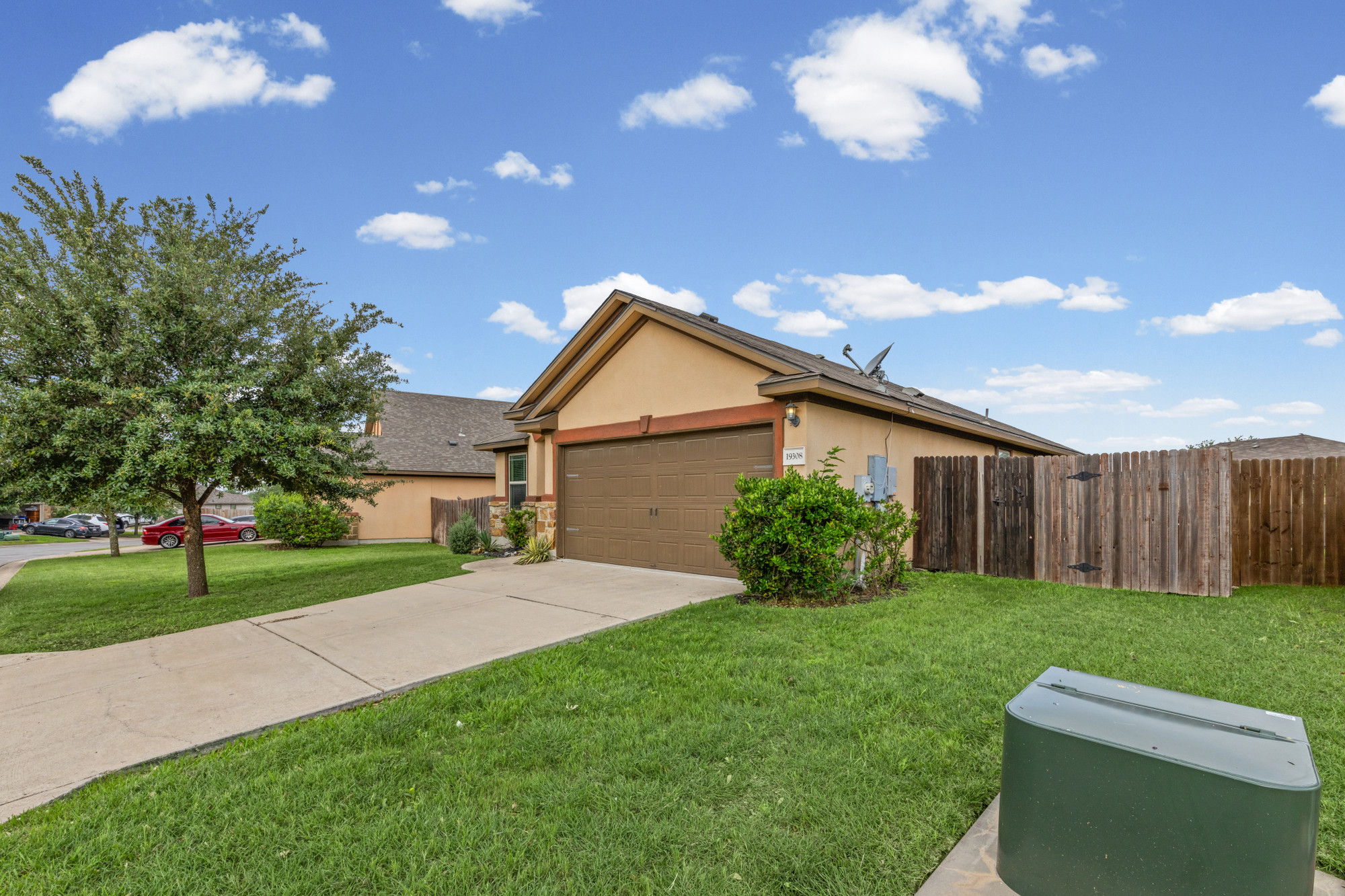 19308 Stokes Lane Pflugerville, TX 78660 - Photo 22 of 27 Single-story stucco exterior with an attached garage, paved driveway, and mature front yard tree