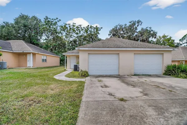 a front view of house with yard and trees