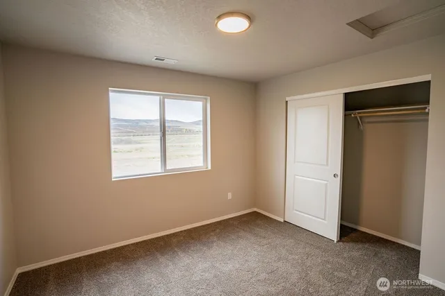 an empty room with windows and closet