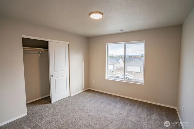 an empty room with windows and closet