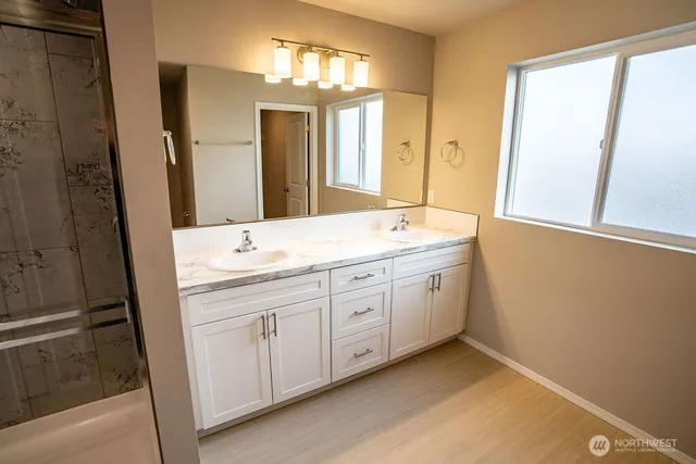 a spacious bathroom with a double vanity sink and a mirror
