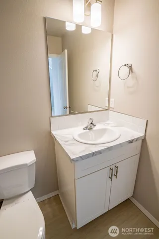 a bathroom with a sink a toilet and mirror