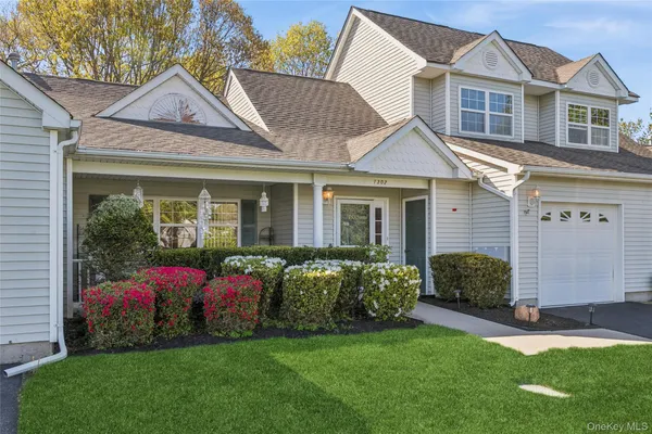 a front view of a house with a garden and plants