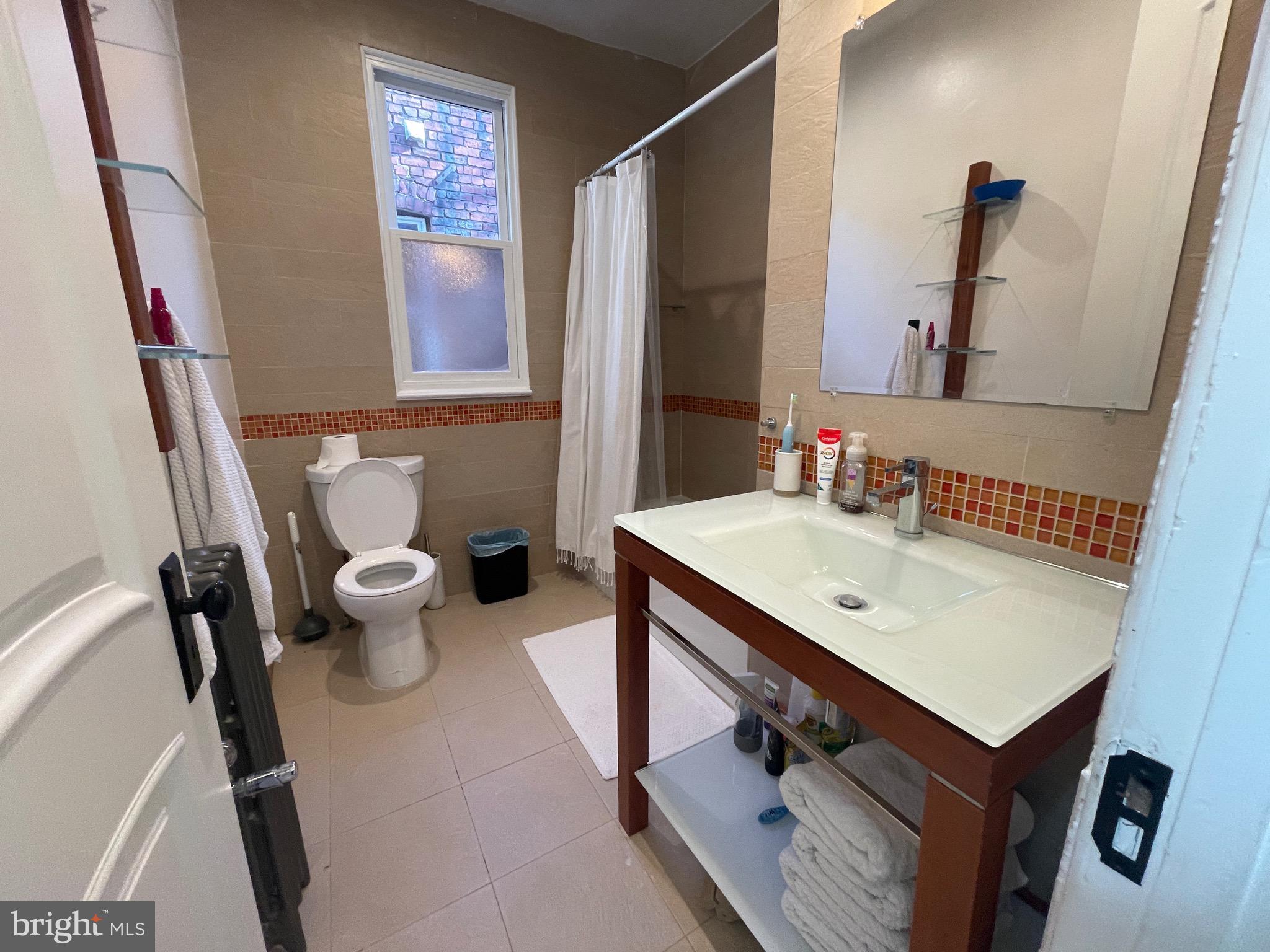 1750 T Street Northwest, Unit B Washington, DC 20009 - Photo 10 of 14 a bathroom with a sink a toilet a mirror and shower