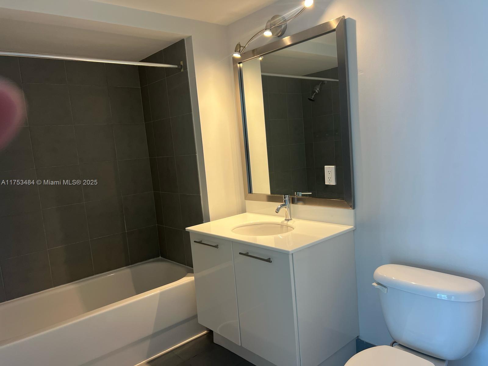 92 Southwest 3rd Street, Unit 2412 Miami, FL 33130 - Photo 11 of 14 a bathroom with a sink and a mirror