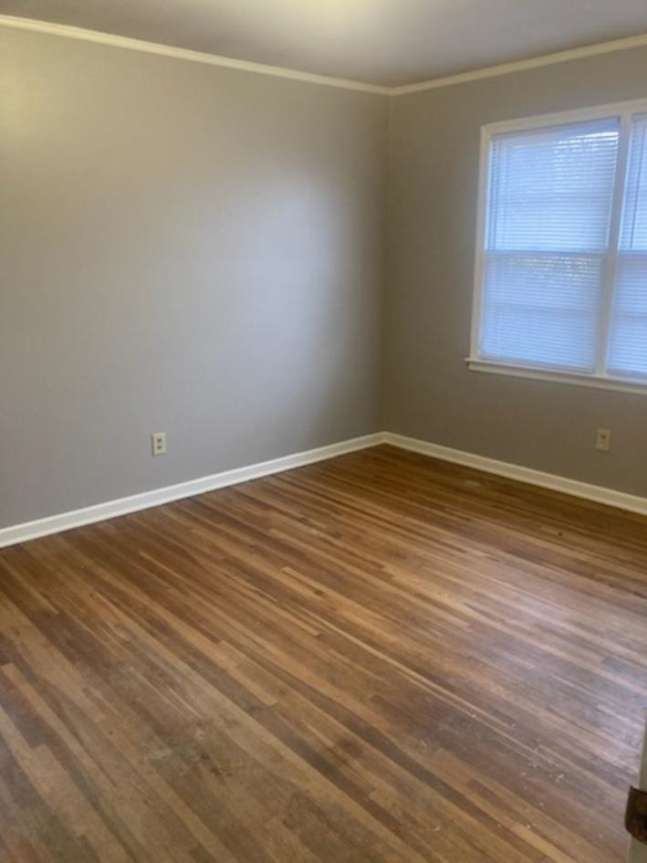6729 Macon Road Memphis, TN 38134 - Photo 7 of 16 a view of an empty room with wooden floor and a window