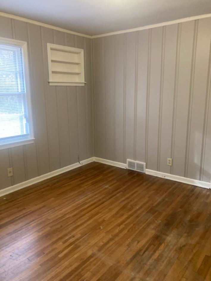 6729 Macon Road Memphis, TN 38134 - Photo 8 of 16 a view of an empty room with wooden floor and a window