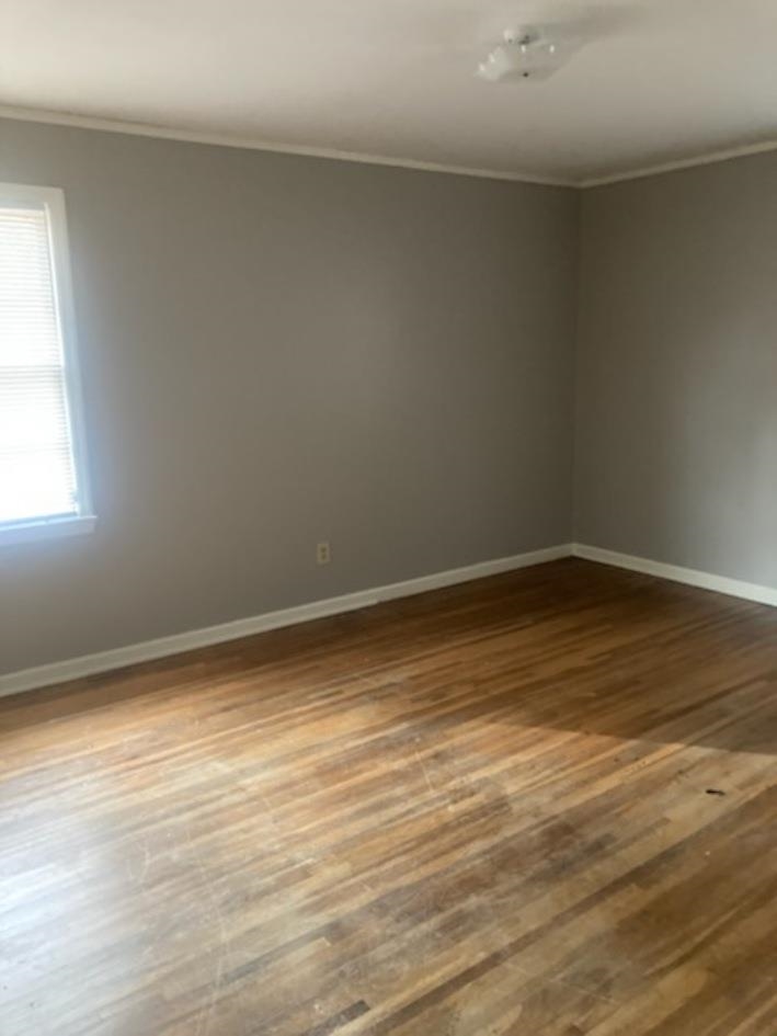 6729 Macon Road Memphis, TN 38134 - Photo 10 of 16 a view of an empty room with wooden floor and a window