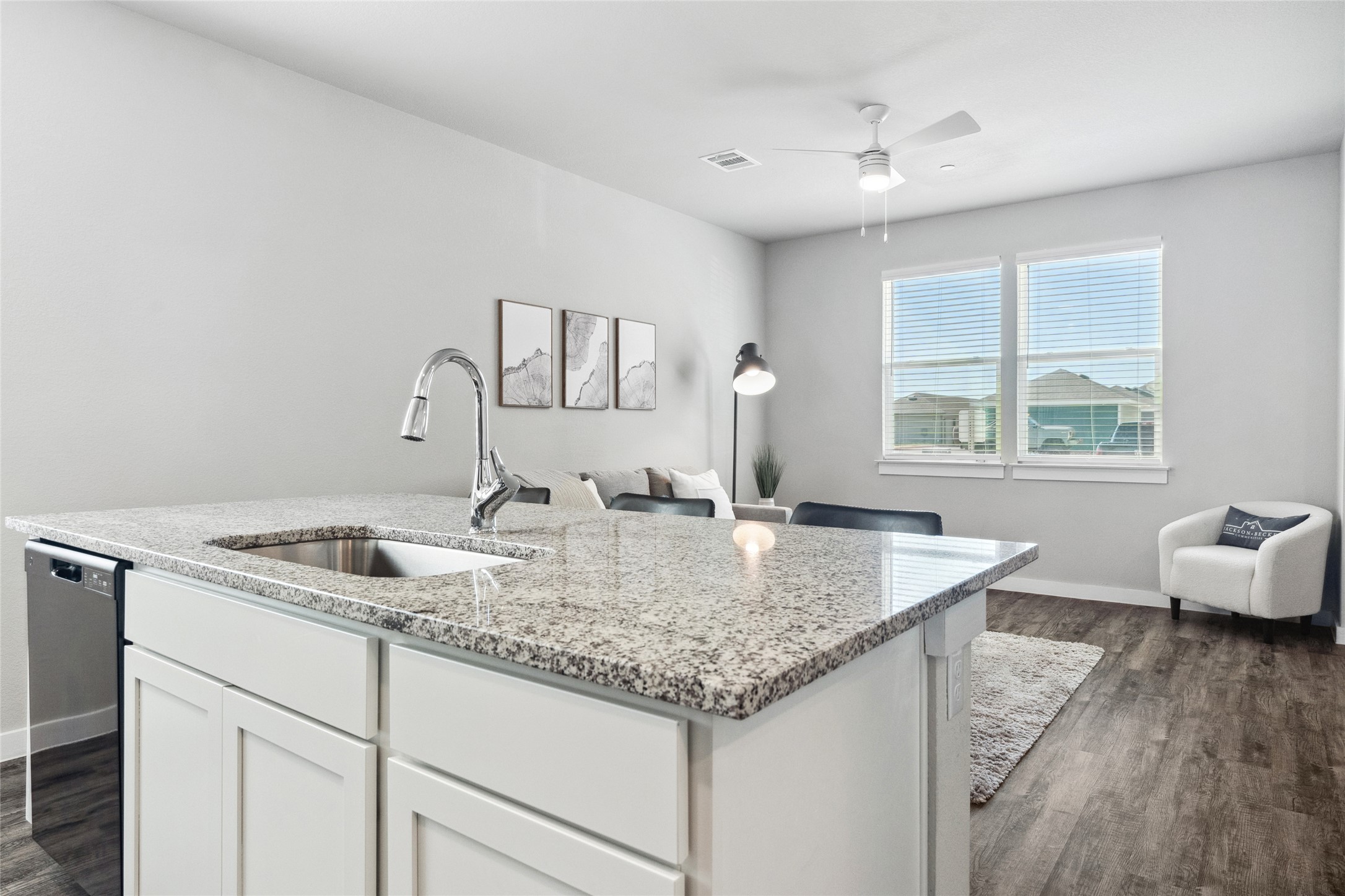 523 Powell Drive, Unit 1101 Leander, TX 78641 - Photo 23 of 24 Kitchen featuring white cabinets, open floor plan, dark wood-type flooring, light stone counters, and stainless steel dishwasher