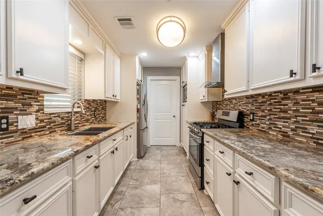 a large kitchen with stainless steel appliances granite countertop a stove sink and cabinets
