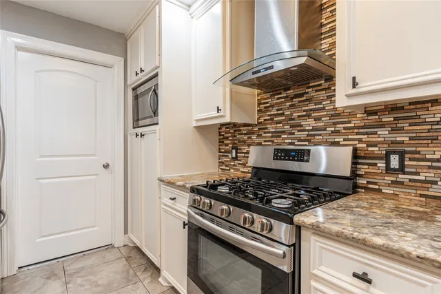 a kitchen with granite countertop a stove and a refrigerator