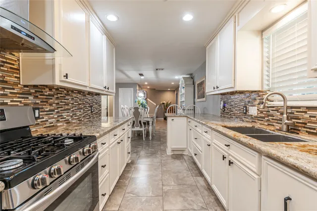 a large kitchen with stainless steel appliances granite countertop a stove and a sink