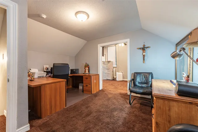 a view of a workspace with furniture and a window