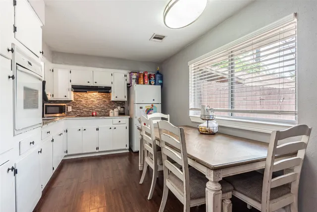 a kitchen with granite countertop a table chairs stove and cabinets