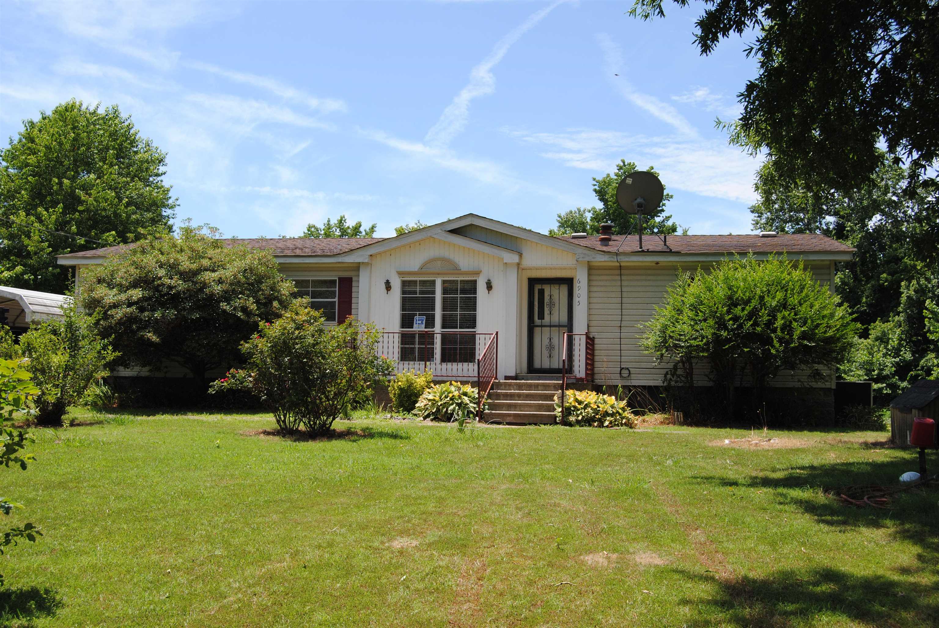6905 Fulton Road Brownsville, TN 38012 - Photo 1 of 22 a front view of a house with garden