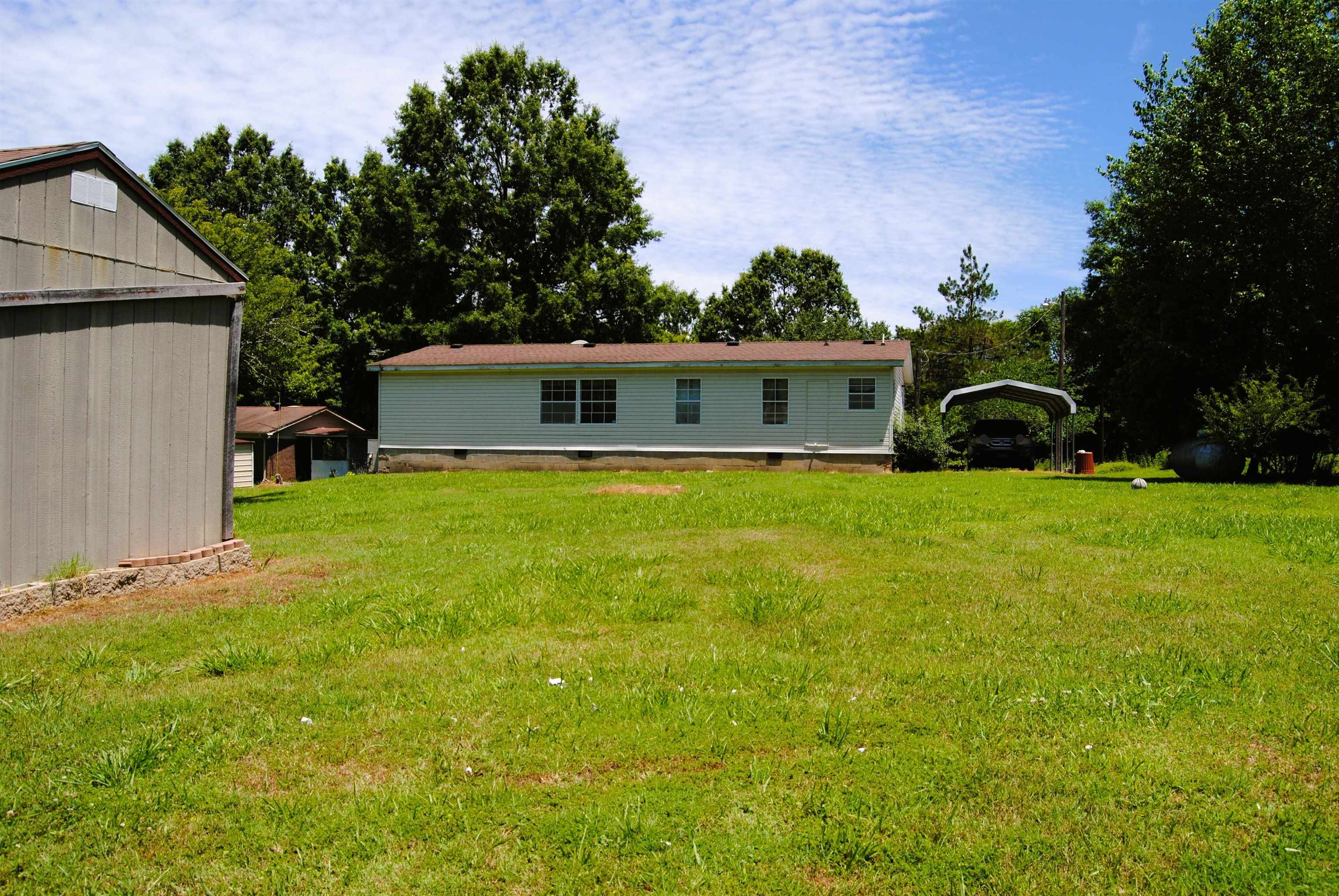 6905 Fulton Road Brownsville, TN 38012 - Photo 3 of 22 a view of house with backyard and a garden