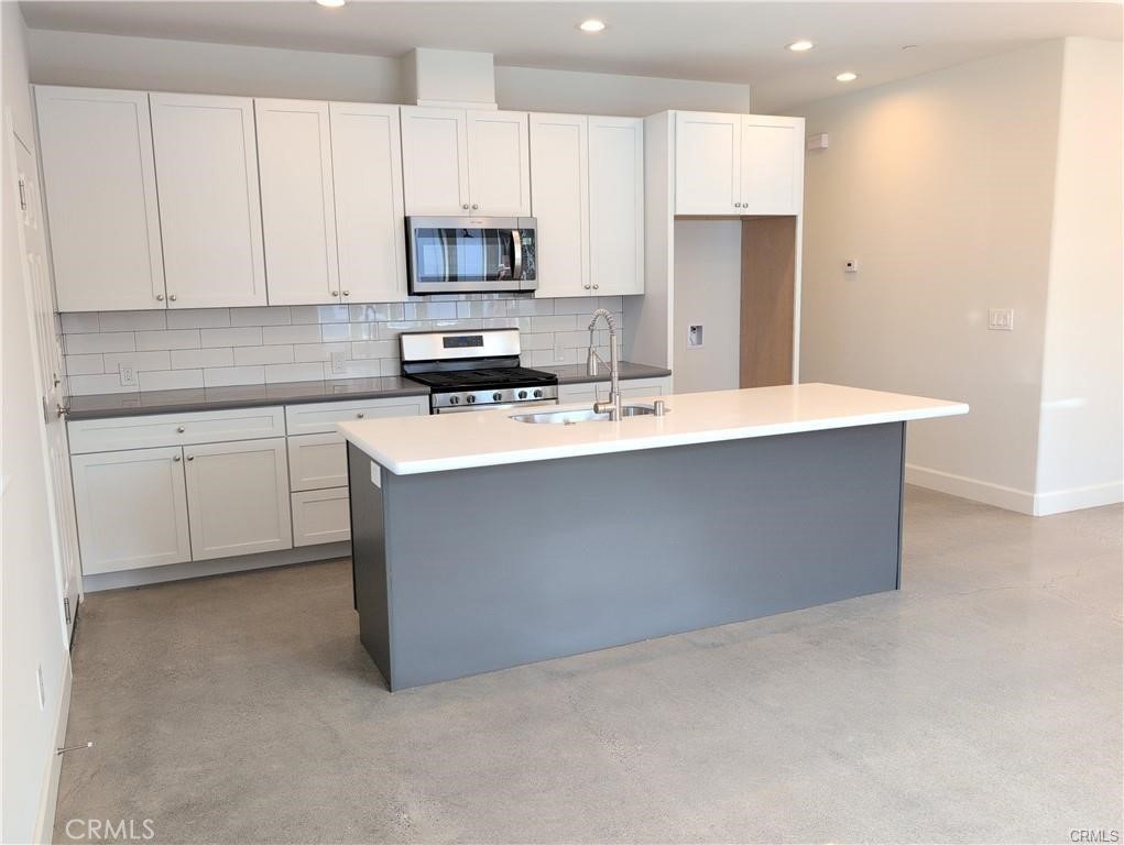 1452 Ronald Way Oceano, CA 93445 - Photo 2 of 11 a kitchen with stainless steel appliances a sink a stove a microwave a refrigerator a white cabinets and a counter top