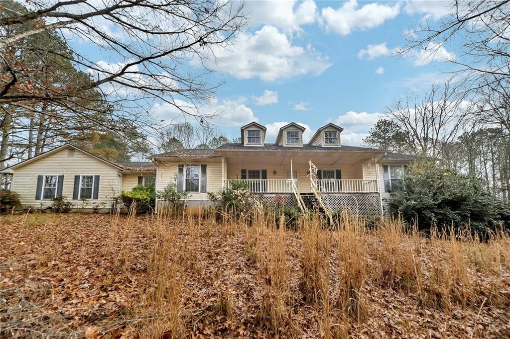 a front view of house with yard and trees around